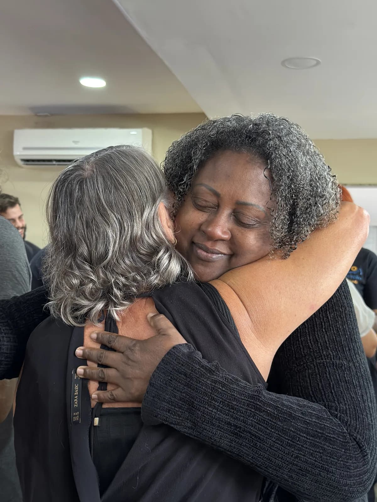 Duas mulheres se abraçando longamente durante um encontro